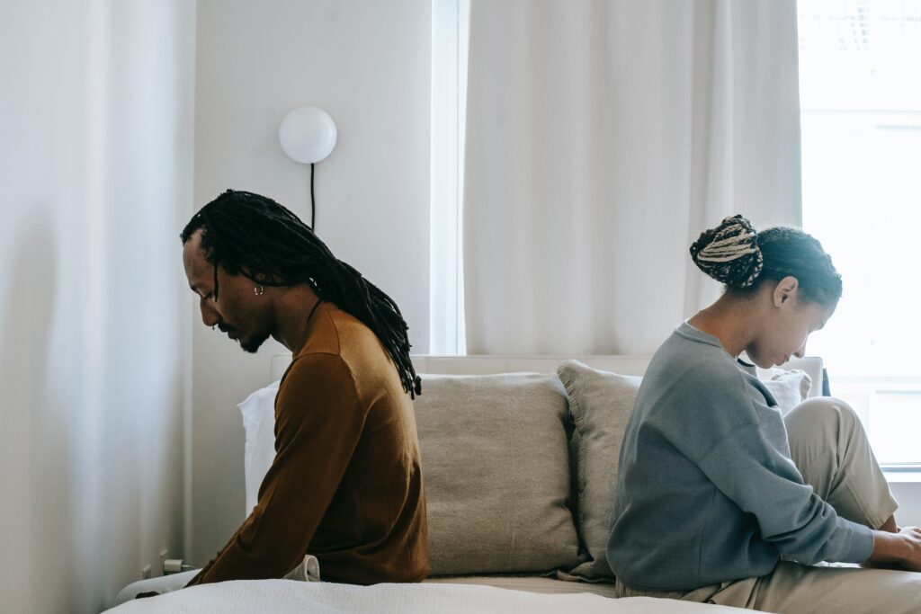 Couple sitting on bed wondering if pornography addiction is real. 